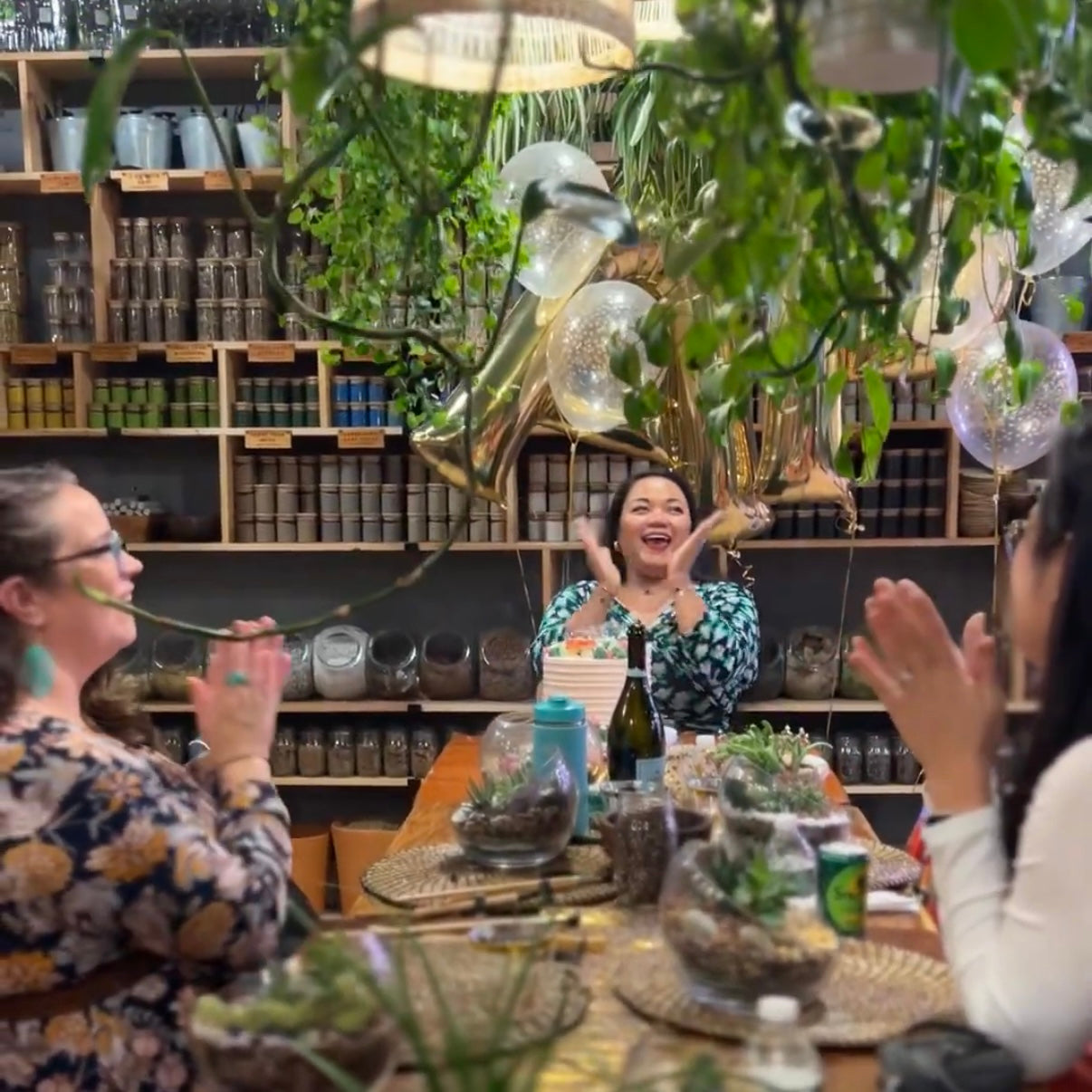 a birthday party in the private event room at spotted leaf, gold balloons overhead and finished terrariums on the table