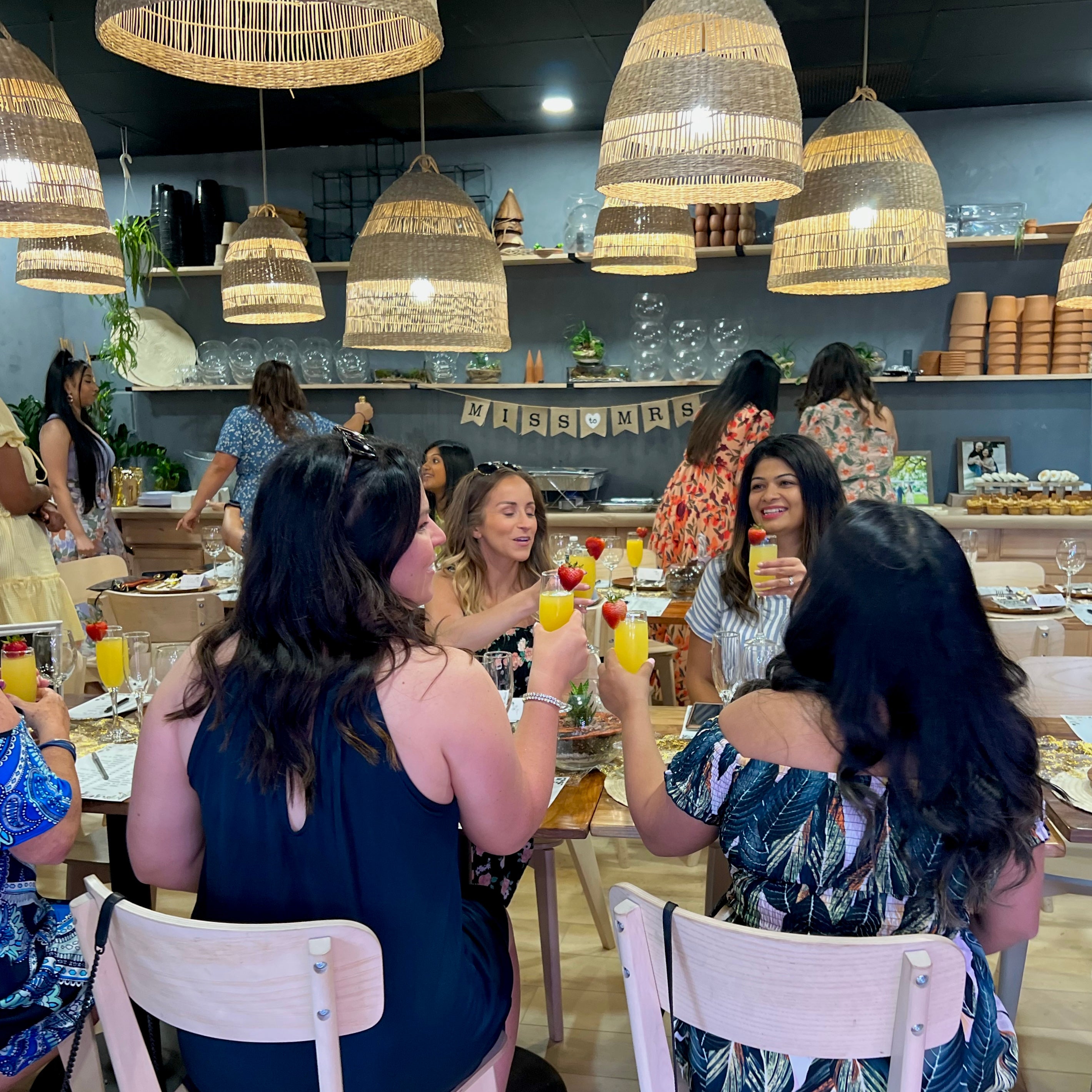 guests toasting at a bridal shower at spotted leaf plant company in somerville, nj, terrariums on the table
