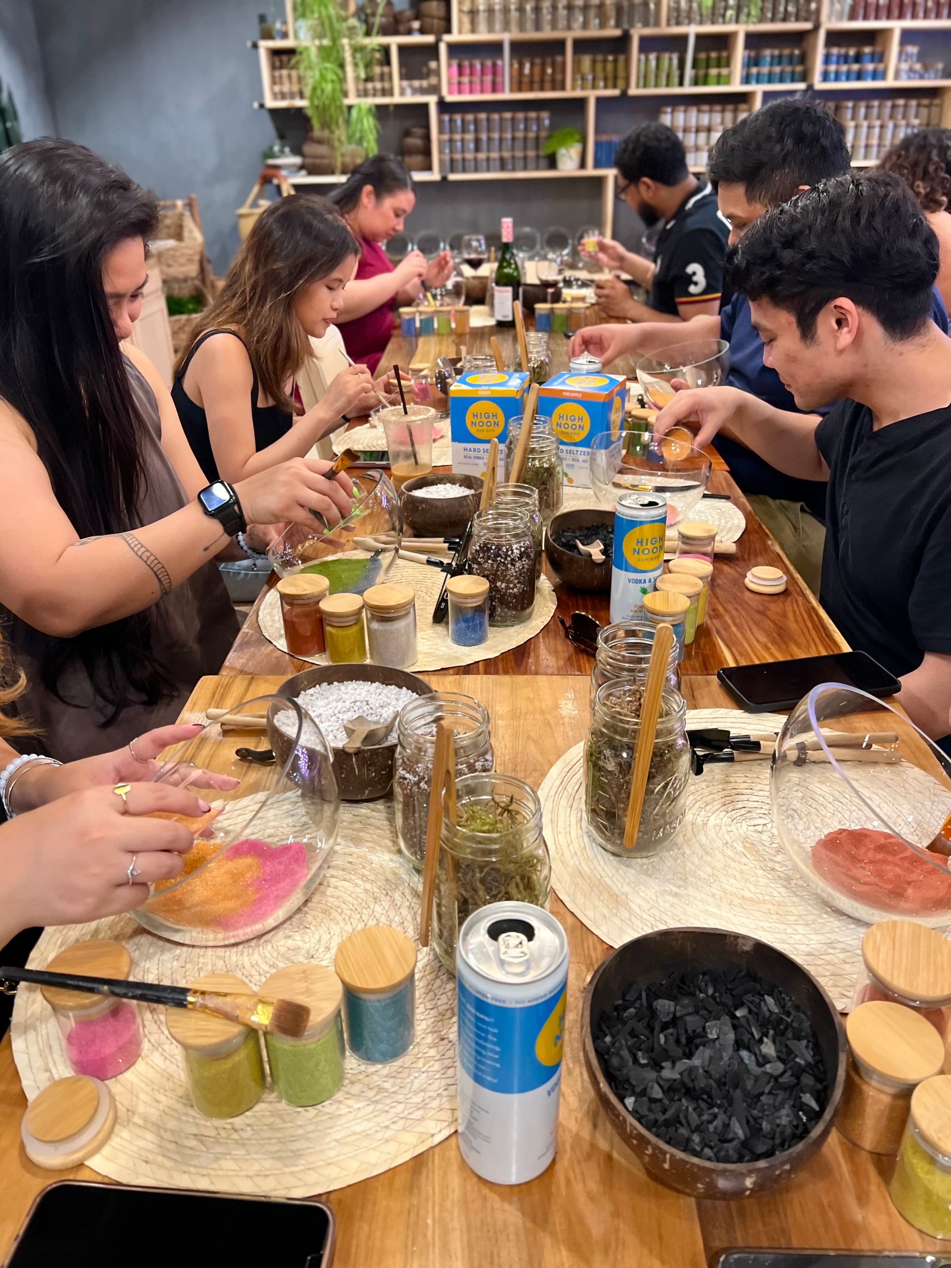 a long wooden table of guests building terrariums at a private event at spotted leaf plant company in somerville, nj